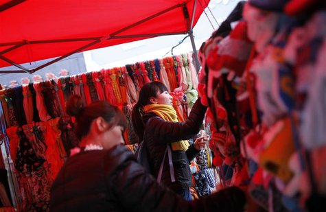 Customers selects hats at a street stall at the business area of Jiaozuo, China's central Henan province, December 20, 2012. REUTERS/Aly Son Customers selects hats at a street stall at the business area of Jiaozuo, China's central Henan province, December 20, 2012. REUTERS/Aly Son