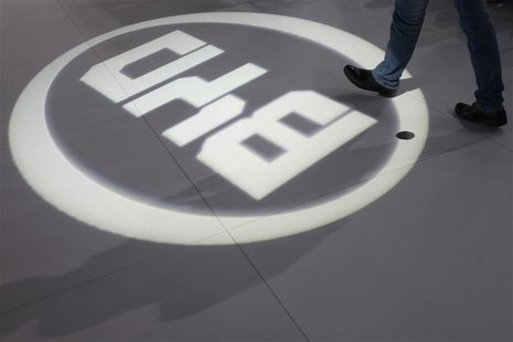 A man walks past a light flashing on the floor in the shape of the logo of BYD Auto during the media preview of the 10th China International A man walks past a light flashing on the floor in the shape of the logo of BYD Auto during the media preview of the 10th China International