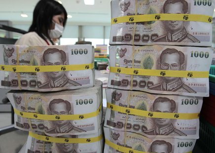 A bank employee counts Thai baht notes at Kasikornbank in Bangkok October 12, 2010. REUTERS/Sukree Sukplang A bank employee counts Thai baht notes at Kasikornbank in Bangkok October 12, 2010. REUTERS/Sukree Sukplang