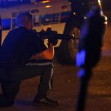 Officer takes his position during the search for suspects in the Boston Marathon bombing early Friday morning in Watertown, Mass. (courtesy Reuters)