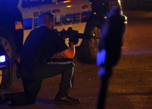 Officer takes his position during the search for suspects in the Boston Marathon bombing early Friday morning in Watertown, Mass. (courtesy Reuters) Officer takes his position during the search for suspects in the Boston Marathon bombing early Friday morning in Watertown, Mass. (courtesy Reuters)