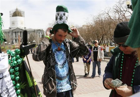 A participant at the 4/20 marijuana holiday buys a hat depicting marijuana plants in Civic Center Park in downtown Denver April 20, 2013. RE A participant at the 4/20 marijuana holiday buys a hat depicting marijuana plants in Civic Center Park in downtown Denver April 20, 2013. RE