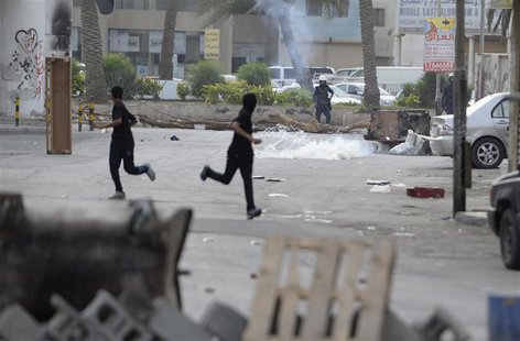Protesters run for cover from the tear-gas fired by riot-police during clashes in the village of Jidhafs, west of Manama, April 20, 2013. RE Protesters run for cover from the tear-gas fired by riot-police during clashes in the village of Jidhafs, west of Manama, April 20, 2013. RE