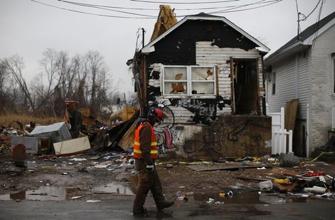 A worker walks past as a house damaged beyond repair by Hurricane Sandy is demolished by heavy machinery in the Ocean Breeze neighborhood of A worker walks past as a house damaged beyond repair by Hurricane Sandy is demolished by heavy machinery in the Ocean Breeze neighborhood of