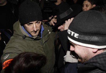 Fashion designer John Galliano surrounded by policemen leaves after a hearing in a police station in Paris February 28, 2011. REUTERS/Jacky Fashion designer John Galliano surrounded by policemen leaves after a hearing in a police station in Paris February 28, 2011. REUTERS/Jacky