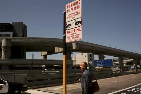 An airline passenger waits at a curb at San Francisco International Airport in San Francisco, California April 22, 2013. REUTERS/Robert Galb An airline passenger waits at a curb at San Francisco International Airport in San Francisco, California April 22, 2013. REUTERS/Robert Galb