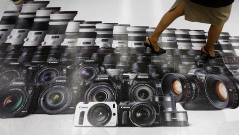 A woman walks on an advertisement for Canon digital cameras at an electronics retail store in Tokyo April 23, 2013. REUTERS/Toru Hanai A woman walks on an advertisement for Canon digital cameras at an electronics retail store in Tokyo April 23, 2013. REUTERS/Toru Hanai