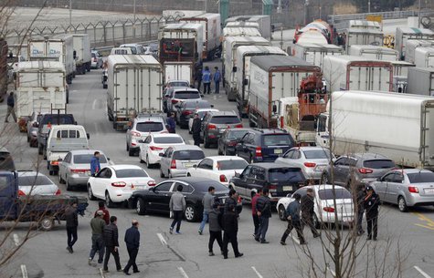 South Korean truck drivers walk to get in their trucks as they leave the South's CIQ (Customs, Immigration and Quarantine) office before goi South Korean truck drivers walk to get in their trucks as they leave the South's CIQ (Customs, Immigration and Quarantine) office before goi