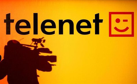 The shadow of a cameraman is seen beside the Belgian cable operator Telenet logo during a news conference in Brussels. REUTERS/Thierry Roge The shadow of a cameraman is seen beside the Belgian cable operator Telenet logo during a news conference in Brussels. REUTERS/Thierry Roge