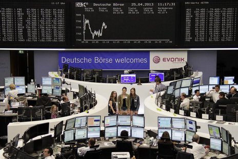 Traders work at their desks in front of the DAX board, as visitors pose for a picture at the Frankfurt stock exchange April 25, 2013. REUTER Traders work at their desks in front of the DAX board, as visitors pose for a picture at the Frankfurt stock exchange April 25, 2013. REUTER