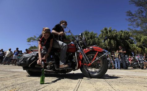 A man and a woman take part in a competition of riding skills in their Harley Davidson motorcycle during Cuba's Second Harley Davidson Conve A man and a woman take part in a competition of riding skills in their Harley Davidson motorcycle during Cuba's Second Harley Davidson Conve