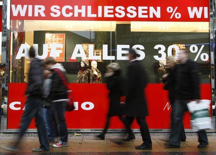 People pass by a clothes shop which will be closed with advertising banners reading 'We are closing, 30% on all' at Berlin's Kurfuerstendamm People pass by a clothes shop which will be closed with advertising banners reading 'We are closing, 30% on all' at Berlin's Kurfuerstendamm