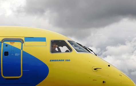 A crew member sits in the cockpit as an Embraer 190 is guided onto its stand ahead of the Farnborough Airshow 2012 in southern England July A crew member sits in the cockpit as an Embraer 190 is guided onto its stand ahead of the Farnborough Airshow 2012 in southern England July