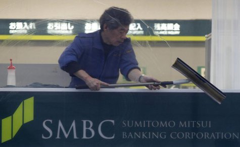 A man cleans up a window at a branch of Sumitomo Mitsui Banking Corporation in Tokyo January 29, 2013. REUTERS/Shohei Miyano A man cleans up a window at a branch of Sumitomo Mitsui Banking Corporation in Tokyo January 29, 2013. REUTERS/Shohei Miyano