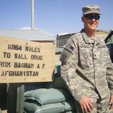 A member of the South Dakota National Guard stands near a Wall Drug sign in Afghanistan - Public domain photo