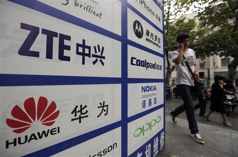 A man walks past an advertisement board showing the logos of Huawei and ZTE on it, outside a mobile phone repair shop in Wuhan October 11, 2 A man walks past an advertisement board showing the logos of Huawei and ZTE on it, outside a mobile phone repair shop in Wuhan October 11, 2