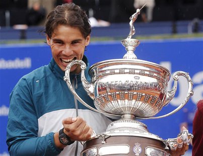 Spain's Rafael Nadal bites the trophy after defeating compatriot Nicolas Almagro in the men's singles final match of the Barcelona Open tenn Spain's Rafael Nadal bites the trophy after defeating compatriot Nicolas Almagro in the men's singles final match of the Barcelona Open tenn
