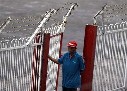 A security personnel wears a cap bearing the brand of Digicel as he mans a gate at a soccer match at Aung San stadium in Yangon April 26, 20 A security personnel wears a cap bearing the brand of Digicel as he mans a gate at a soccer match at Aung San stadium in Yangon April 26, 20