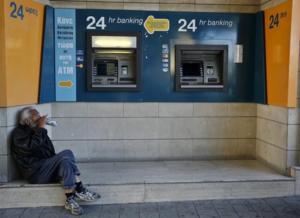 A man drinks beer near ATMs outside a branch of the Bank of Cyprus in Nicosia March 28, 2013. REUTERS/Yannis Behrakis A man drinks beer near ATMs outside a branch of the Bank of Cyprus in Nicosia March 28, 2013. REUTERS/Yannis Behrakis