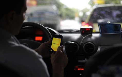 A taxi driver checks an app on his smartphone in Rio de Janeiro April 15, 2013. REUTERS/Ricardo Moraes A taxi driver checks an app on his smartphone in Rio de Janeiro April 15, 2013. REUTERS/Ricardo Moraes