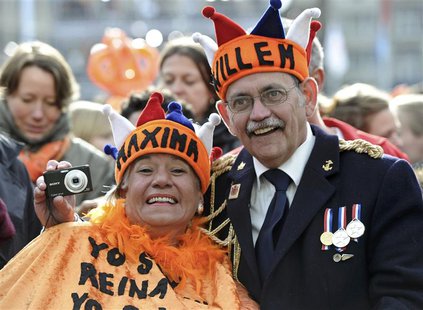 A couple waits for Queen Beatrix's abdication ceremony outside the Royal Palace in Amsterdam April 30, 2013. REUTERS/Paul Vreeker A couple waits for Queen Beatrix's abdication ceremony outside the Royal Palace in Amsterdam April 30, 2013. REUTERS/Paul Vreeker