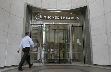 A worker enters the Thomson Reuters building in the Canary Wharf financial district of London August 6, 2009. REUTERS/Simon Newman A worker enters the Thomson Reuters building in the Canary Wharf financial district of London August 6, 2009. REUTERS/Simon Newman