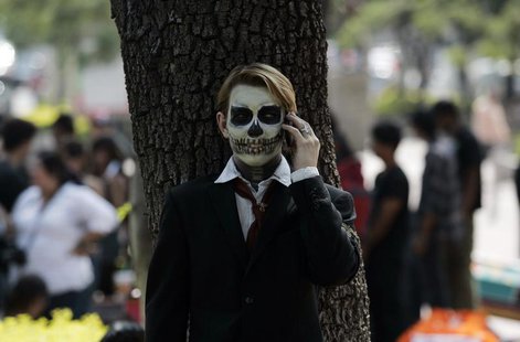 A fine arts student wears make-up as he talks on the phone during the Catrina's parade in Guadalajara October 26, 2012. REUTERS/Alejandro Ac A fine arts student wears make-up as he talks on the phone during the Catrina's parade in Guadalajara October 26, 2012. REUTERS/Alejandro Ac