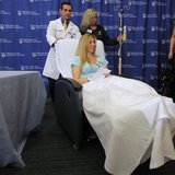 Boston Marathon bombing victim Heather Abbott (C), helped by Dr. Eric Bluman (L) and Melissa Burke, RN, smiles as she leaves a news conferen