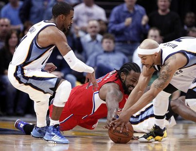 Los Angeles Clippers center Ronny Turiaf fights for a loose ball against Memphis Grizzlies guards Jerryd Bayless (R) and Mike Conley (L) dur Los Angeles Clippers center Ronny Turiaf fights for a loose ball against Memphis Grizzlies guards Jerryd Bayless (R) and Mike Conley (L) dur