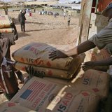 Men transport humanitarian food aid onto pirogues at Mopti February 4, 2013. REUTERS/Alain Amontchi