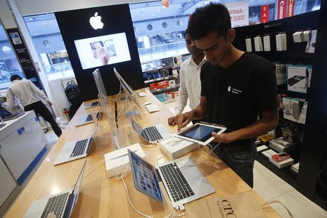 A salesperson unpacks an Apple iPad Mini to test it for a customer in the Apple specialty section of a Croma retail store in Mumbai February A salesperson unpacks an Apple iPad Mini to test it for a customer in the Apple specialty section of a Croma retail store in Mumbai February