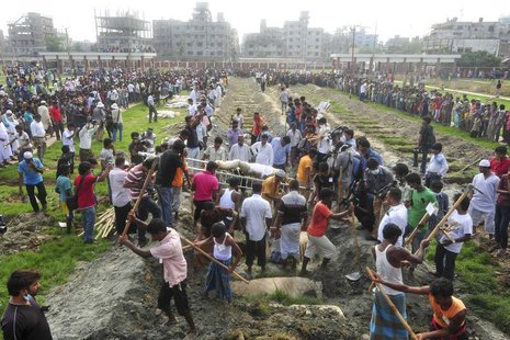 Workers dig mass graves during a mass burial of unidentified garment workers, who died in the collapse of the Rana Plaza building in Savar, Workers dig mass graves during a mass burial of unidentified garment workers, who died in the collapse of the Rana Plaza building in Savar,