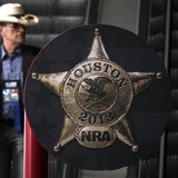 A man rides down an escalator at the George R. Brown Convention Center, ahead of the National Rifle Association's (NRA) annual meeting in Ho A man rides down an escalator at the George R. Brown Convention Center, ahead of the National Rifle Association's (NRA) annual meeting in Ho