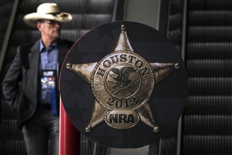 A man rides down an escalator at the George R. Brown Convention Center, ahead of the National Rifle Association's (NRA) annual meeting in Ho A man rides down an escalator at the George R. Brown Convention Center, ahead of the National Rifle Association's (NRA) annual meeting in Ho