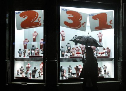 People walk past the shop window of a jewelry store in central Barcelona November 27, 2012. REUTERS/Albert Gea People walk past the shop window of a jewelry store in central Barcelona November 27, 2012. REUTERS/Albert Gea