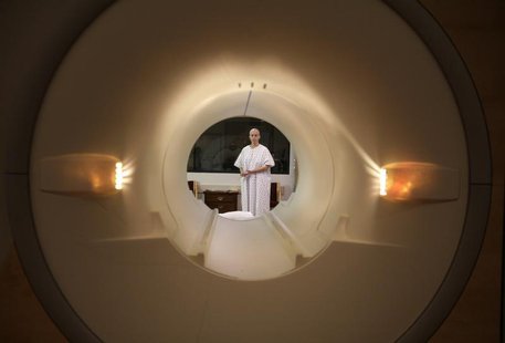 A cancer patient is seen through the tube of a magnetic resonance imaging scanner as she prepares to enter the MRI machine for an examinatio A cancer patient is seen through the tube of a magnetic resonance imaging scanner as she prepares to enter the MRI machine for an examinatio