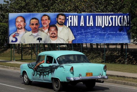 A car drives past a poster of the five Cuban prisoners in U.S. jails, in Havana March 30, 2012. REUTERS/Enrique de la Osa A car drives past a poster of the five Cuban prisoners in U.S. jails, in Havana March 30, 2012. REUTERS/Enrique de la Osa