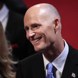Florida Governor Rick Scott greets an attendee in the audience before the start of the final U.S. presidential debate in Boca Raton, Florida