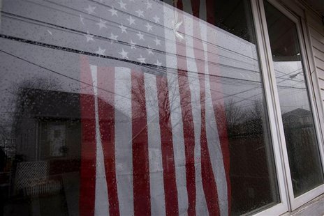 An American flag is seen through the window of a destroyed and abandoned home after Hurricane Sandy on Tarlton Street in the Oakwood Beach s An American flag is seen through the window of a destroyed and abandoned home after Hurricane Sandy on Tarlton Street in the Oakwood Beach s