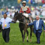 Orb trainer Claude McGaughey (R) walks his horse, with Jockey Joel Rosario aboard, to the winner's circle after the running of the 139th Ken