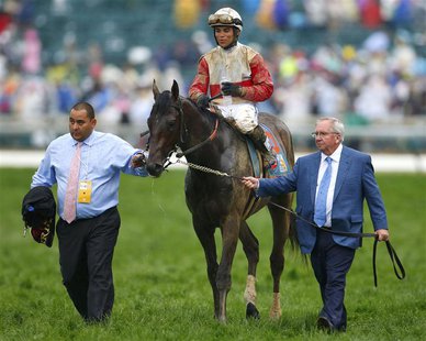 Orb trainer Claude McGaughey (R) walks his horse, with Jockey Joel Rosario aboard, to the winner's circle after the running of the 139th Ken Orb trainer Claude McGaughey (R) walks his horse, with Jockey Joel Rosario aboard, to the winner's circle after the running of the 139th Ken