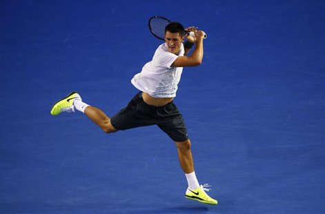 Bernard Tomic of Australia hits a return to Roger Federer of Switzerland during their men's singles match at the Australian Open tennis tour Bernard Tomic of Australia hits a return to Roger Federer of Switzerland during their men's singles match at the Australian Open tennis tour