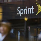 People walk past a Sprint store in New York December 17, 2012. REUTERS/Andrew Kelly