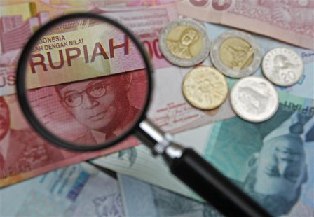 A 100,000 Indonesian rupiah note is seen through a magnifying glass among other Southeast Asian currencies in this photo illustration taken A 100,000 Indonesian rupiah note is seen through a magnifying glass among other Southeast Asian currencies in this photo illustration taken