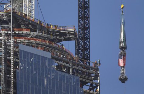 The final section of the spire that will top off One World Trade Center is raised past iron workers to the top of the building in New York, The final section of the spire that will top off One World Trade Center is raised past iron workers to the top of the building in New York,