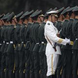 A member of the People's Liberation Army's navy guard of honour adjusts military uniforms before an official welcome ceremony outside the Gr A member of the People's Liberation Army's navy guard of honour adjusts military uniforms before an official welcome ceremony outside the Gr
