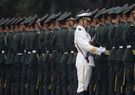 A member of the People's Liberation Army's navy guard of honour adjusts military uniforms before an official welcome ceremony outside the Gr A member of the People's Liberation Army's navy guard of honour adjusts military uniforms before an official welcome ceremony outside the Gr