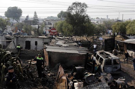 Police officers stand at an area damaged by the explosion of a gas tanker truck in San Pedro Xalostoc, on the outskirts of Mexico City May 7 Police officers stand at an area damaged by the explosion of a gas tanker truck in San Pedro Xalostoc, on the outskirts of Mexico City May 7
