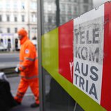 A trash collector walks by a Telekom Austria phone box in Vienna February 8, 2013. REUTERS/Heinz-Peter Bader A trash collector walks by a Telekom Austria phone box in Vienna February 8, 2013. REUTERS/Heinz-Peter Bader