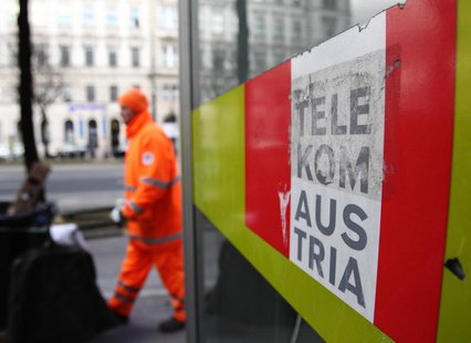 A trash collector walks by a Telekom Austria phone box in Vienna February 8, 2013. REUTERS/Heinz-Peter Bader A trash collector walks by a Telekom Austria phone box in Vienna February 8, 2013. REUTERS/Heinz-Peter Bader